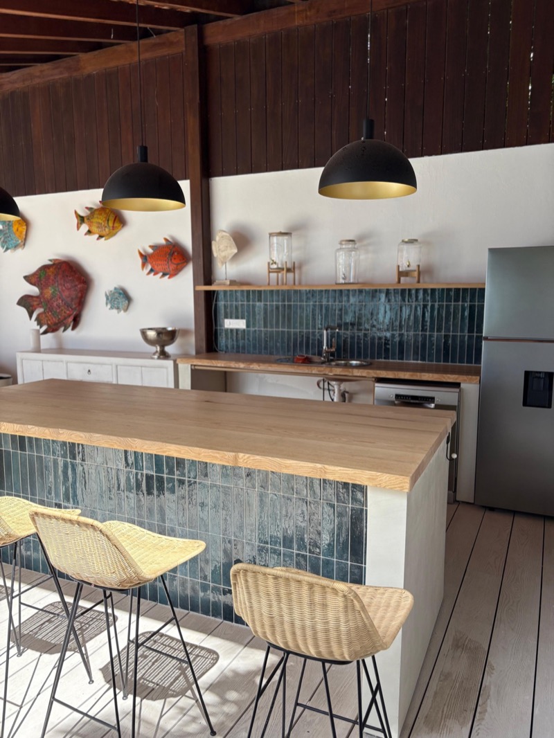 Cuisine sur mesure avec bar, carrelage bleu et suspensions décoratives en Martinique — MAD Projects